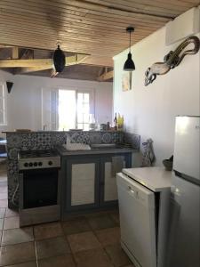 a kitchen with a stove and a refrigerator at Chalet PLEINSUD in Le Tampon