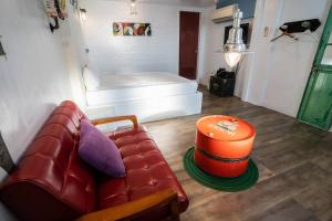 a living room with a red couch and an orange ottoman at Flower House B&B in Jiufen