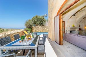 Hamlet 1 Holiday Home في Għasri: فناء مع طاولة وكراسي ومسبح