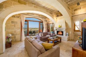 salon z kanapą i kominkiem w obiekcie Hamlet 1 Holiday Home w mieście Għasri