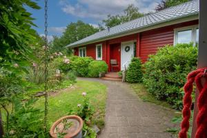 una casa roja con un camino que conduce a un patio en Haus Hygge en Holm