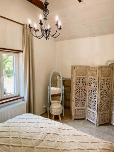 a bedroom with a bed and a chair and a chandelier at Bungalov Trapani in Růžová