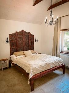 a bedroom with a large bed with a wooden headboard at Bungalov Trapani in Růžová