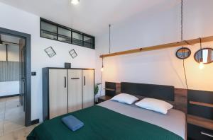 - une chambre avec un grand lit et une couverture verte dans l'établissement Apartament z Ogródkiem Gdańsk Stare Miasto, à Gdańsk