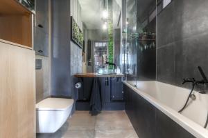 a bathroom with a tub and a toilet and a sink at Apartament z Ogródkiem Gdańsk Stare Miasto in Gdańsk