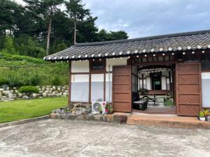 a small house with a pavilion in a yard at Hakdong Hanok Pension in Gangneung