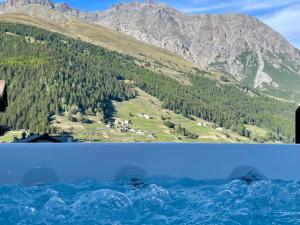 a view from the water of a mountain at Hotel San Carlo, tra Bormio e Livigno in Valdidentro