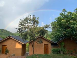 a rainbow in the sky above a house at Mun Homestay in Ha Giang