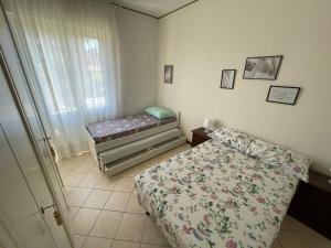 a small bedroom with a bed and a window at Appartamento Note d’estate in Marina di Andora