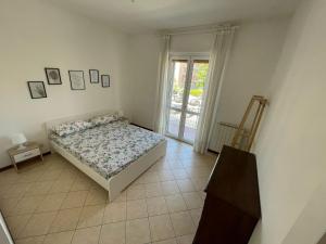 a bedroom with a bed and a glass door at Appartamento Note d’estate in Marina di Andora