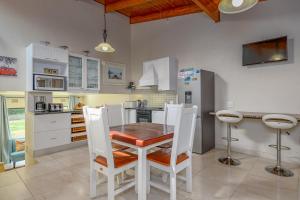 een keuken met een houten tafel en witte stoelen bij San Lameer Villa 3104 - 3 Bedroom Superior - 6 pax - San Lameer Rental Agency in Southbroom