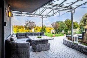 a patio with a couch and a table and chairs at Ferienwohnung BodenseeSuite in Friedrichshafen in Friedrichshafen