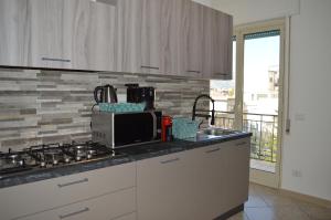 kuchnia ze zlewem i kuchenką górny piekarnik w obiekcie Emerella Guest House Siderno Beach w mieście Siderno Marina