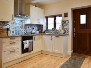 a kitchen with white cabinets and a stove top oven at Sparrow - Uk30747 in Acton Trussell