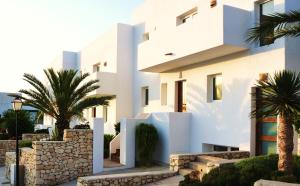 a white house with palm trees in front of it at Real Agua Amarga Las Villas in Agua Amarga