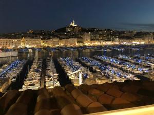 uma vista para uma marina à noite com barcos estacionados em Hostel Ambassade Bretonne Vieux-Port em Marselha