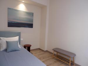 um quarto com uma cama e uma cadeira em Kaiser Luxury Suites em Achílleion