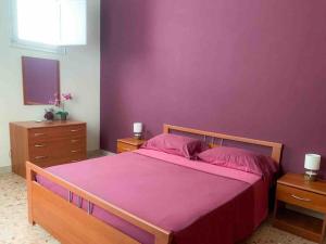 トラーパニにあるCasa Vacanza Rivettiの紫の壁のベッドルーム1室(大型ベッド1台付)