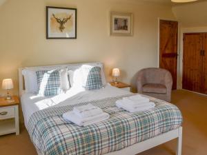a bedroom with a bed with towels on it at Teasel in Stalham