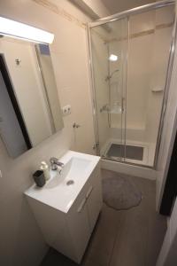 a white bathroom with a sink and a shower at Apartment Nostra Casa Orsera in Vrsar