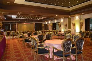 TGN SUITES - HOTEL في رايبور: قاعة احتفالات مع طاولات وكراسي في غرفة