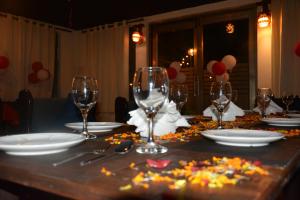 een tafel met wijnglazen en bloemen erop bij TGN SUITES - HOTEL in Raipur
