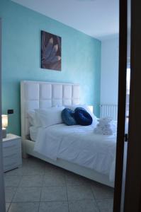 sypialnia z białym łóżkiem z 2 niebieskimi poduszkami w obiekcie Emerella Guest House Siderno Beach w mieście Siderno Marina
