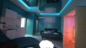 Pokój z łóżkiem i niebieskimi światłami na suficie w obiekcie Apartman Melody w mieście Paraćin