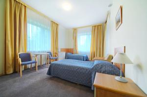 pokój hotelowy z łóżkiem, stołem i krzesłami w obiekcie Perła Bieszczadów - Dom Wczasowy w mieście Czarna