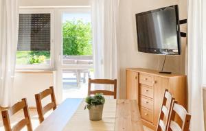 uma sala de jantar com uma mesa e uma televisão por cima em Amazing Home In Tlen With Kitchen em Tleń