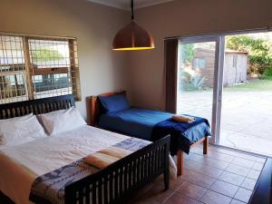una camera da letto con due letti e una porta scorrevole in vetro di 30 Branderdraai a Hermanus