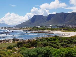 una spiaggia con montagne sullo sfondo e persone sulla spiaggia di 30 Branderdraai a Hermanus