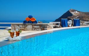 a swimming pool with blue water and a view of the ocean at Miramare Hotel in Chora Folegandros