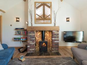 a living room with a fireplace and a tv at Daisy in Scruton