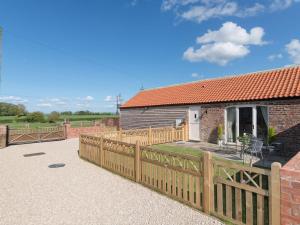 a house with a wooden fence and a patio at Daisy in Scruton