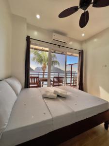 a bedroom with a bed with a view of the ocean at Rosanna's Pension in El Nido