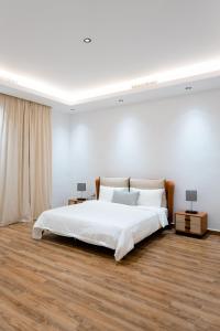 1 dormitorio blanco con 1 cama grande y 2 lámparas en Grande Beach en An Nāmī