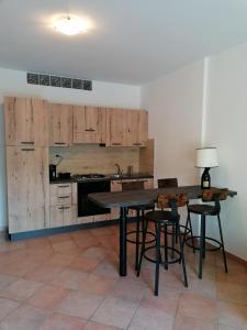 a kitchen with wooden cabinets and a table and chairs at La Casa di Golia in Bagni San Filippo