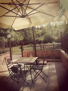 a table and chairs under an umbrella on a patio at La Casa di Golia in Bagni San Filippo