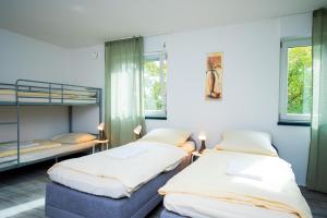 a bedroom with two bunk beds and two windows at Neubau für 4 Personen Eigene küche und Bad Netflix Spätere Check in in Nuremberg