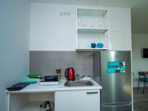 eine kleine Küche mit einem Kühlschrank aus Edelstahl in der Unterkunft Neubau für 4 Personen Eigene küche und Bad Netflix Spätere Check in in Nürnberg