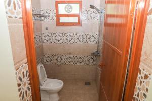 ein kleines Bad mit einem WC und einer Uhr an der Wand in der Unterkunft Nima guest house in Nizwa
