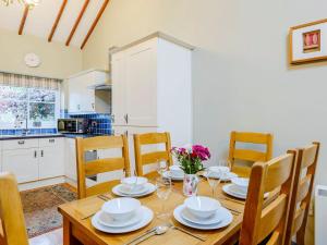 Caeathro的住宿－Ysgubor - Uk31389，厨房以及带木桌和椅子的用餐室。