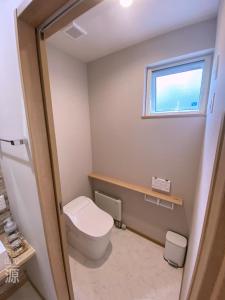 a bathroom with a toilet and a window at 山の源-Yama No Minamoto in Furano