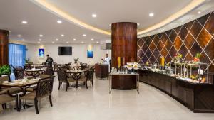 restauracja ze stołami i krzesłami oraz bar w obiekcie Savoy Suites Hotel Apartment - Newly Renovated w Dubaju