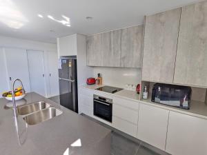a kitchen with white cabinets and stainless steel appliances at Nineteen On Gregory G02 in South West Rocks