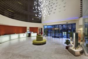 a lobby with a green chair in the middle of a building at TUl BLUE Side Adult Only 16 Plus - Ultra All Inclusive in Side +44 photos