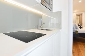 eine weiße Küche mit einem Waschbecken im Zimmer in der Unterkunft Earls Court West Serviced Apartments by Concept Apartments in London