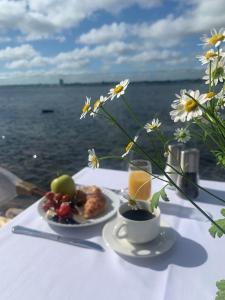 een tafel met twee borden eten en een vaas met bloemen bij Hørby Færgekro in Holbæk