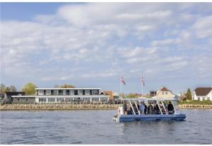 Un gruppo di persone su una barca sull'acqua di Hørby Færgekro a Holbæk